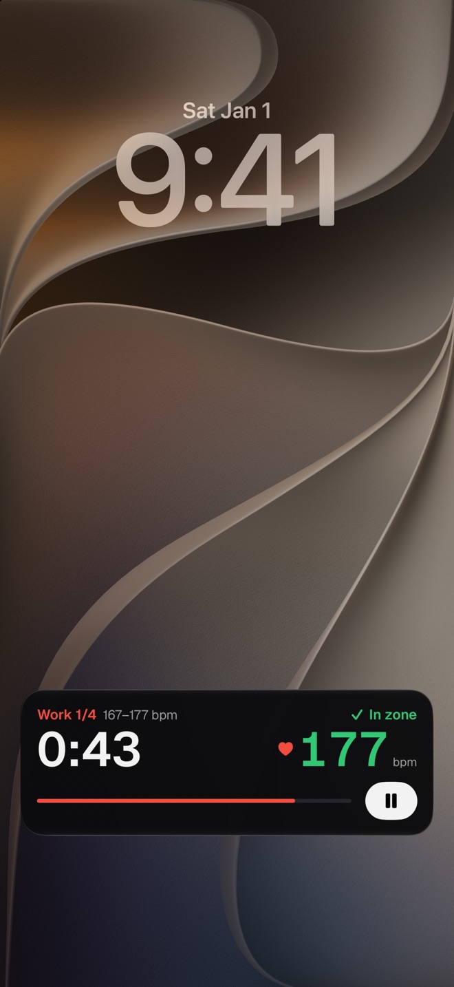 An iPhone lock screen with Fjell's Live Activity: the work round, the time left, heart rate in green, in the zone, and a pause button.